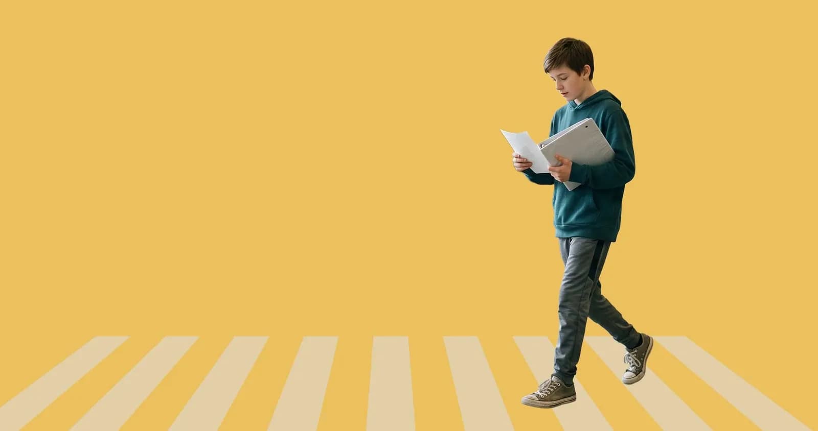 Student walking looking at papers in hand