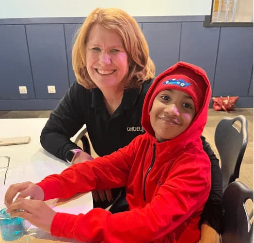 A teacher helping a student with classwork at a table