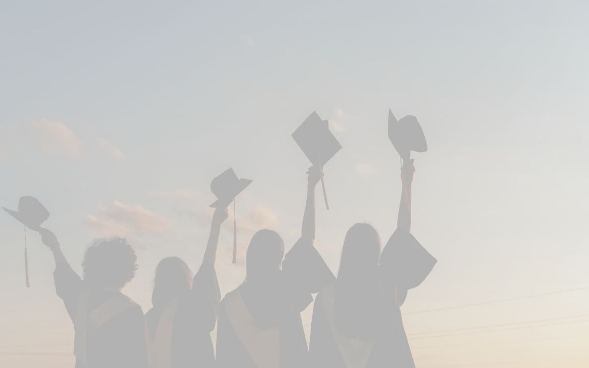 Grayed out image of graduates holding up their graduation caps in celebration. Ohdela Testimonial. A Game-Changer for Our Family.